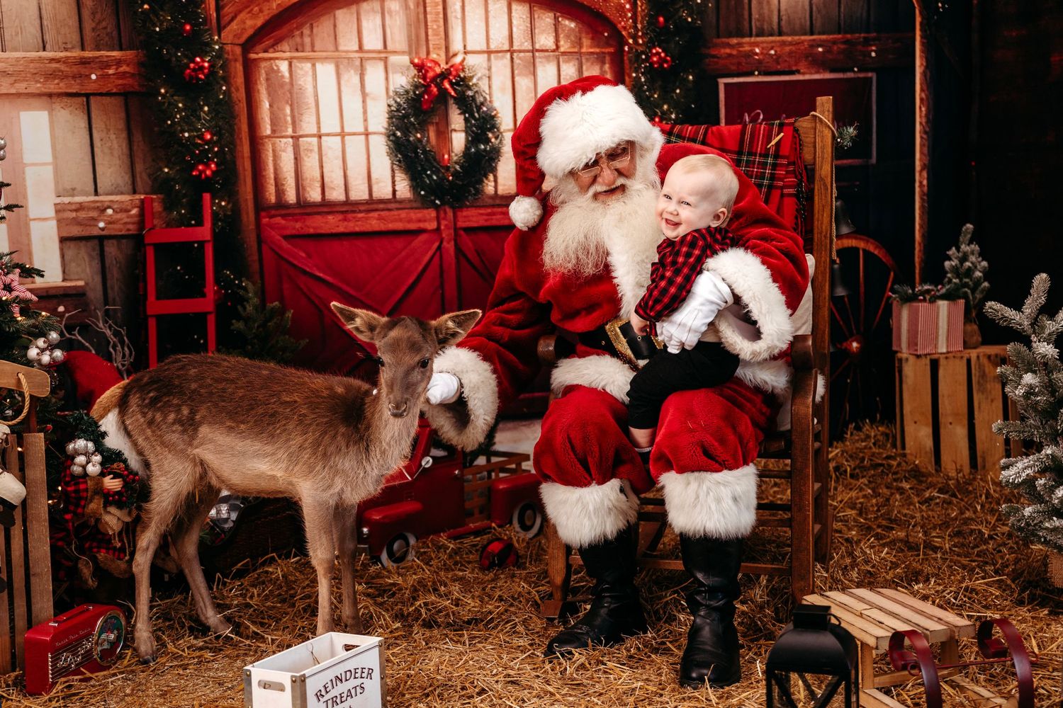 Festive holiday scene with decorated Christmas trees, reindeer, and traditional holiday decor in a rustic setting. Santa photographer