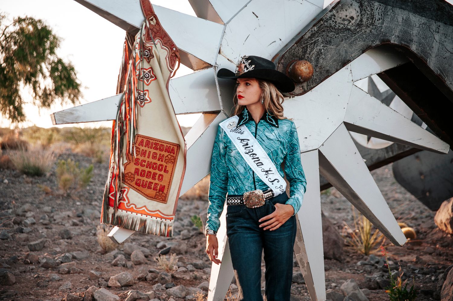 Western-themed portrait against a vintage backdrop in warm desert lighting.
