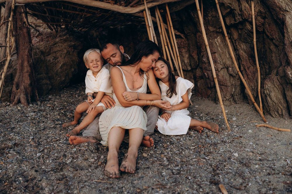 A series of warm-toned beach photos showing intimate family moments during a sunset photoshoot along a rocky coastline.