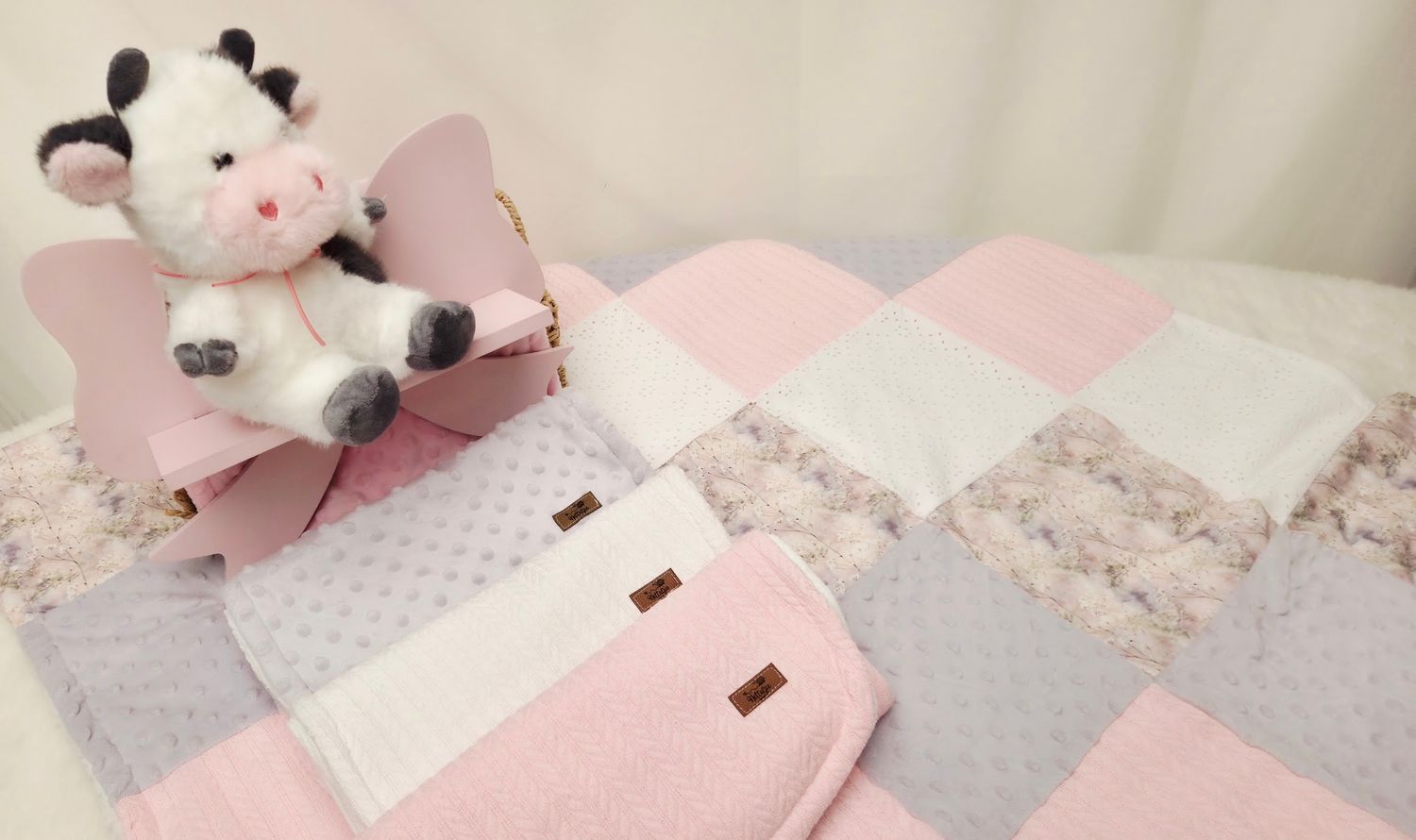 Neutral toned bedding with leopard print patterns and decorative bows arranged artfully.