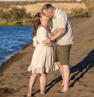 Couple kissing on sandy beach.