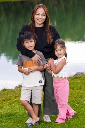 Mother and children in front of lake.