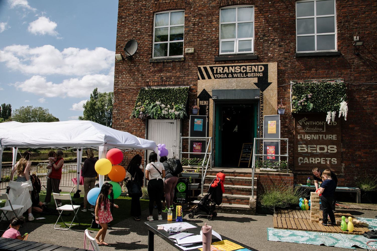 Colorful balloons decorate the entrance of a brick building during a community event.