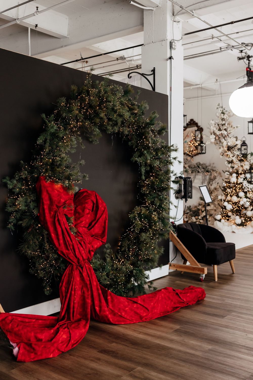 A series of holiday photos showing a large green wreath with flowing red fabric against a white studio backdrop.