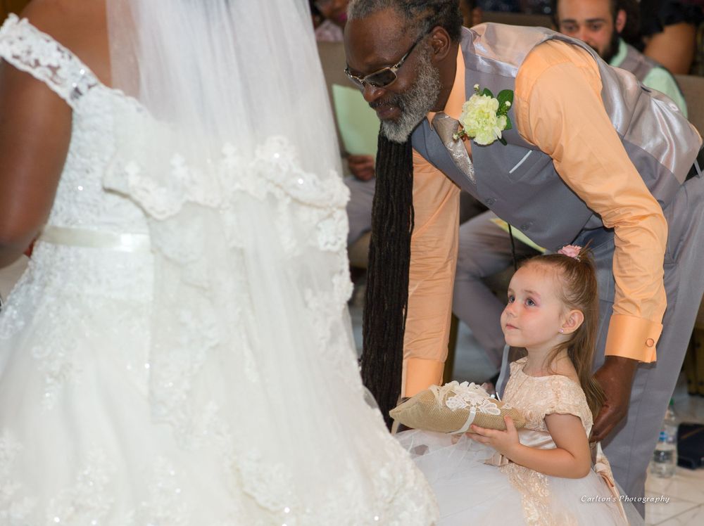 Wedding celebration with guests gathering around bride in flowing white gown.