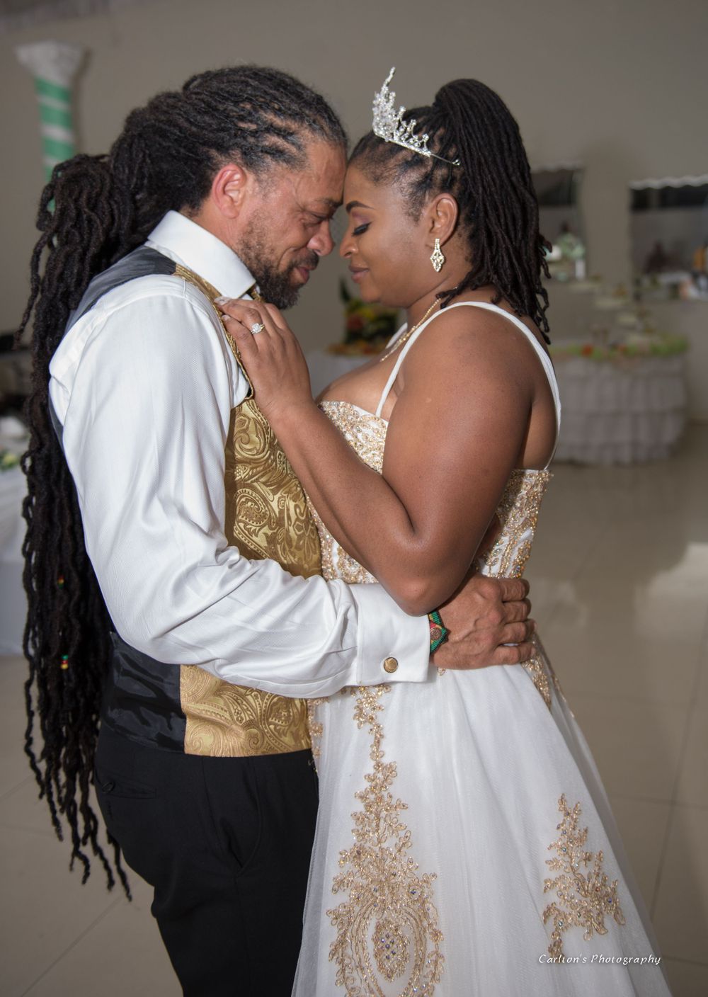 An intimate dance moment between newlyweds in elegant white and gold attire.