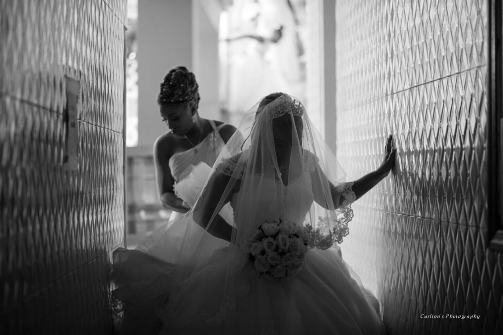 Dramatic black and white silhouette of bride against textured wall.