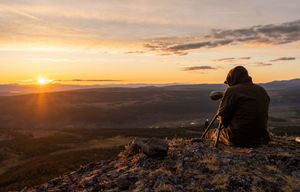 Dramatic sunset landscape photography session on rocky mountain summit.
