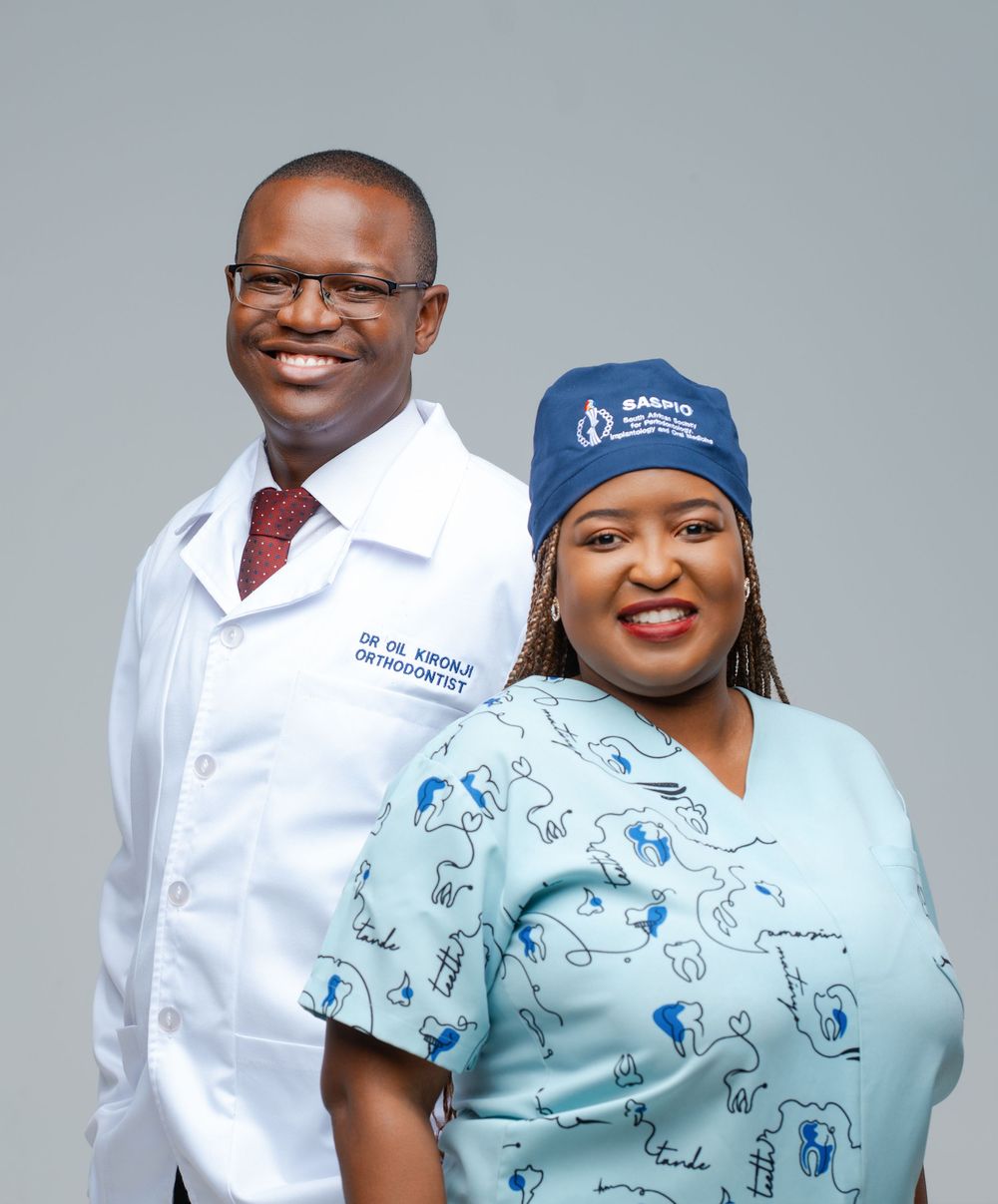 Healthcare professionals in white coats and scrubs stand together in a medical setting.