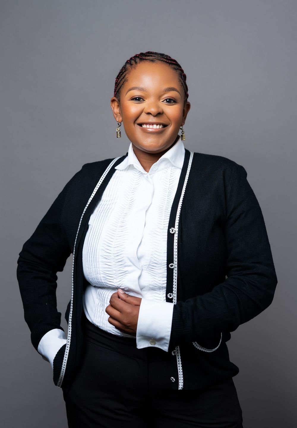 Professional studio portraits showing a person in formal black and white business attire against a gray background.