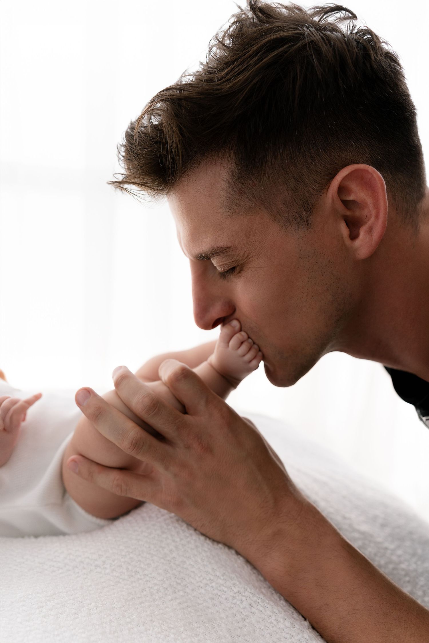 Intimate black and white portrait showing gentle parental affection.
