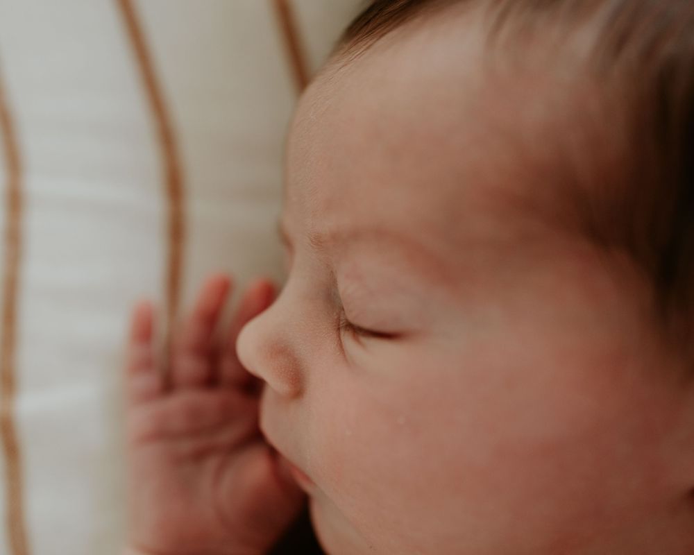 A series of intimate close-up shots showing a baby's gentle facial features in soft, warm lighting.