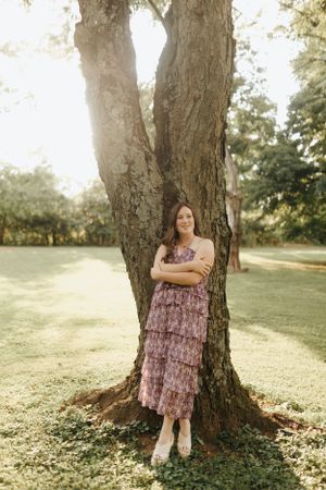 Columbus high school senior leaning against a tree at the Park of Roses.