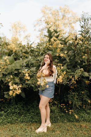 High school senior happily posing amongst the flowers at the Columbus Park of Roses