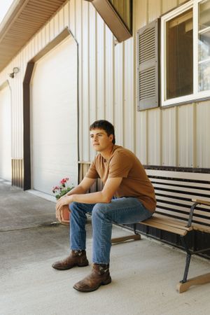 High school senior on grandparents farm, looking stoic.