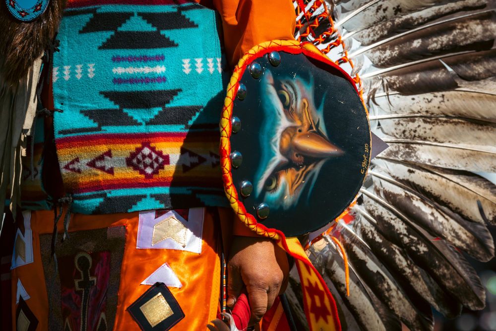 Traditional Native American ceremonial items including turquoise blanket and decorated shield.