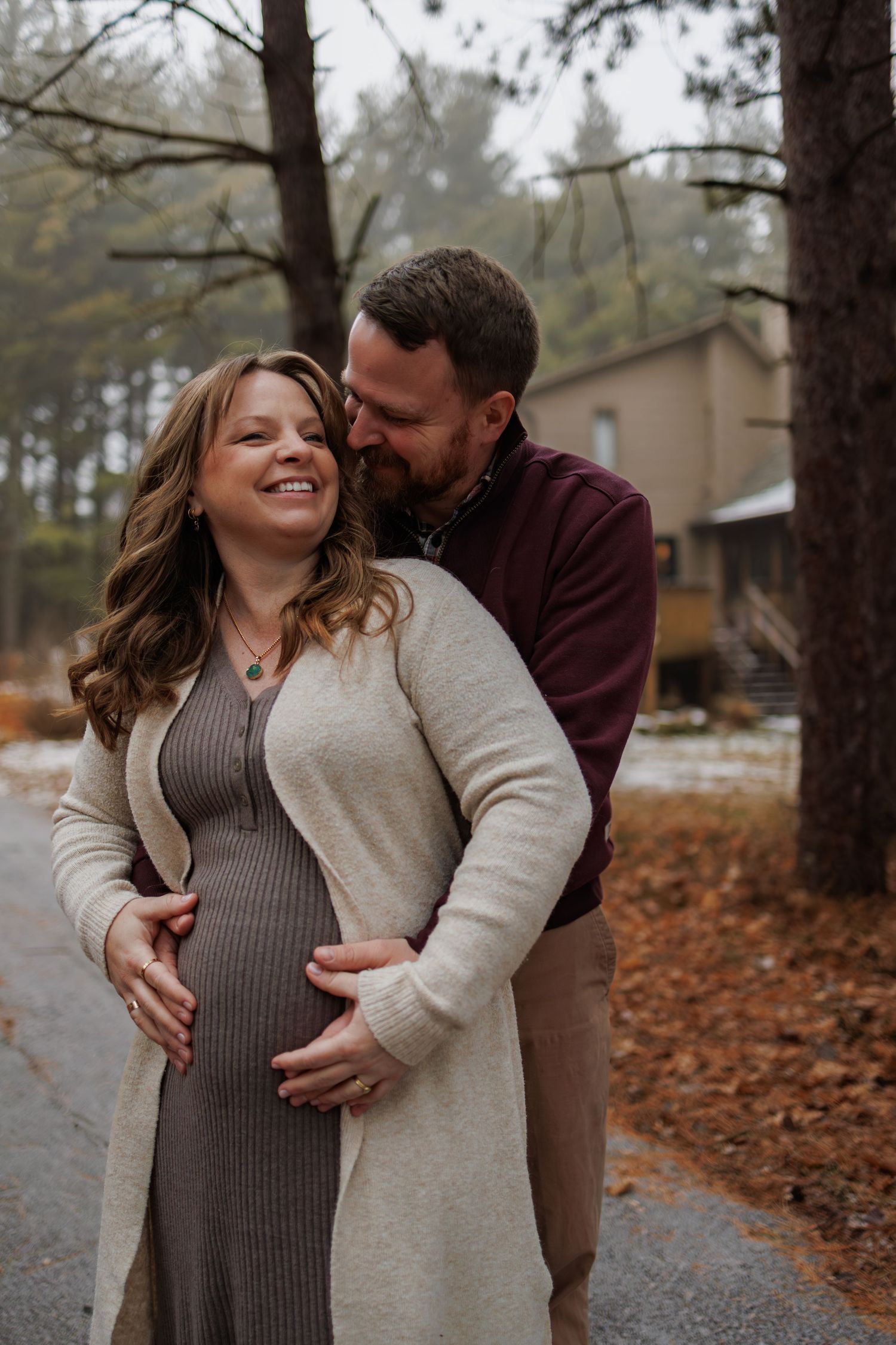 Expectant couple sharing a loving moment outdoors during autumn.