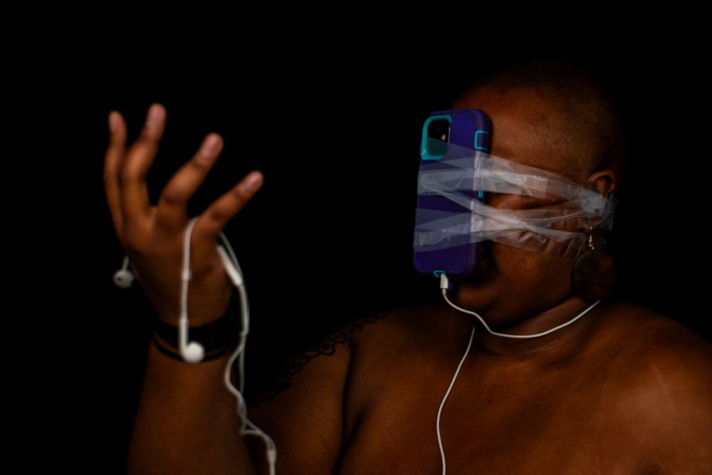 Person wearing glowing earphones illuminated against dark background with ethereal blue lighting effects.