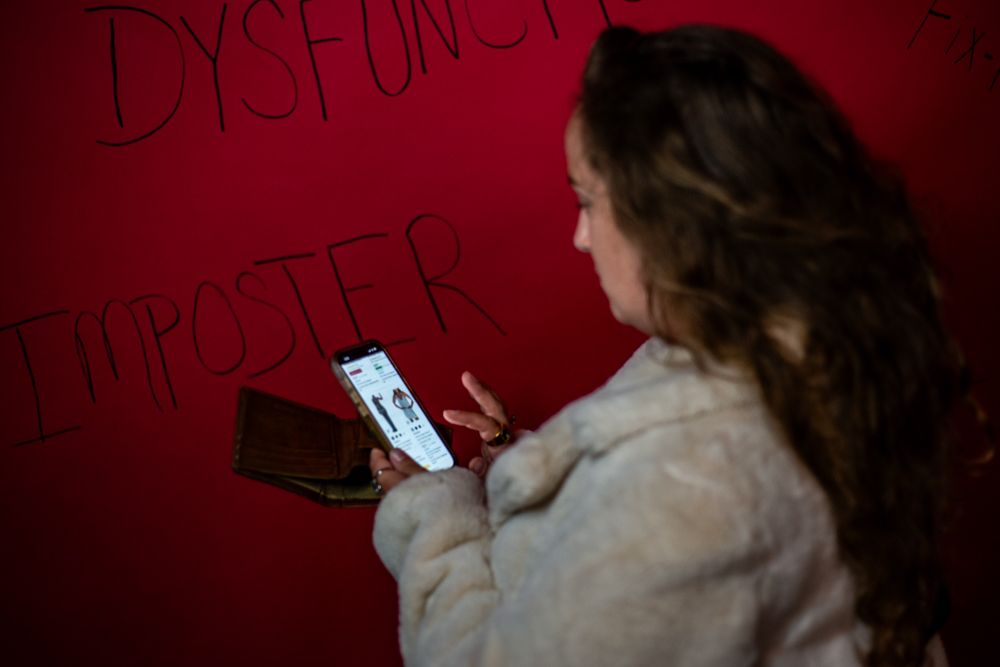 Person drawing letters on red wall using black marker with animated line quality and energetic motion.