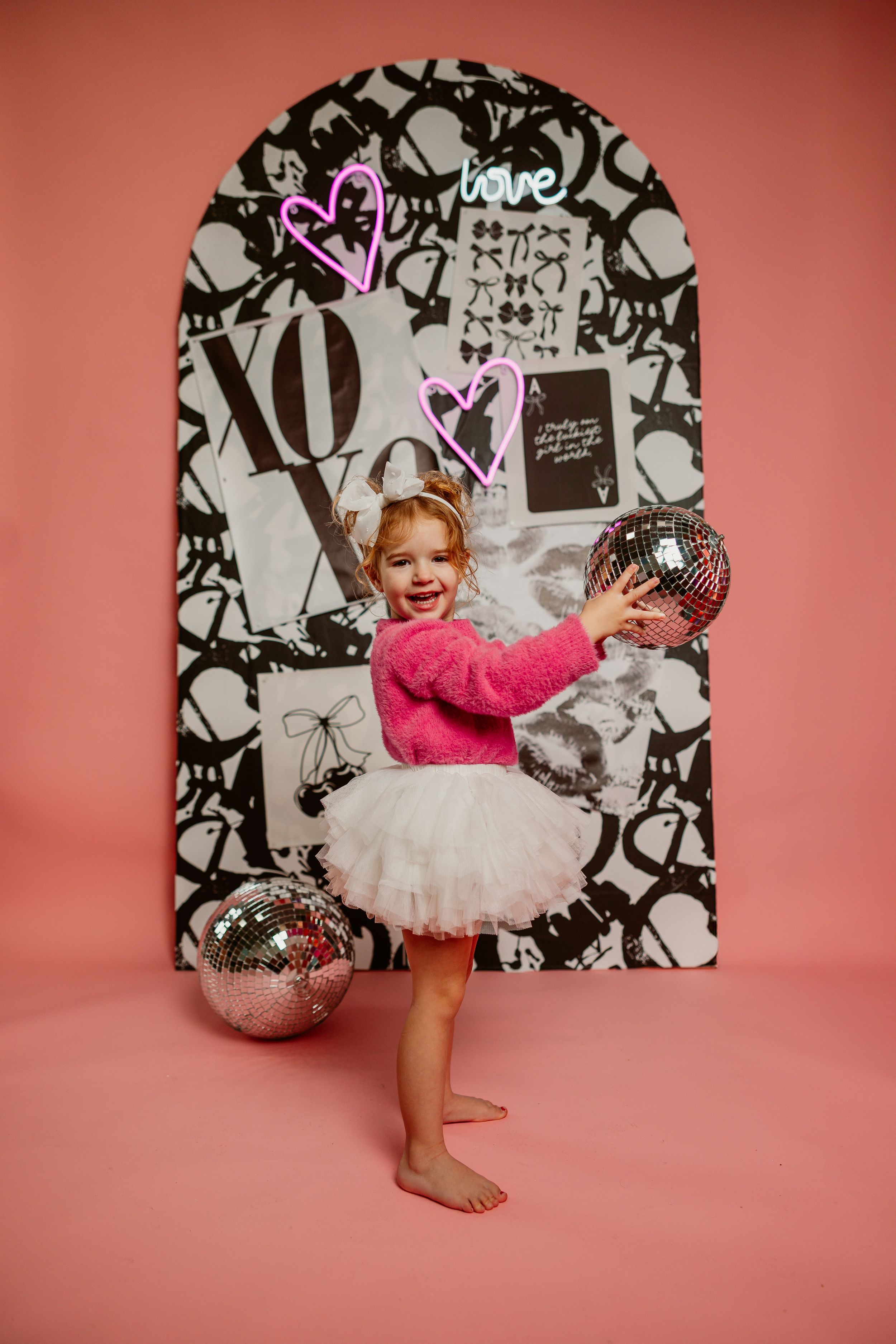 Dance-themed photo shoot with pink tutu against decorative background Paola, Kansas studio