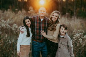 Family portrait session outdoors with warm Kansas sunset lighting and casual attire.