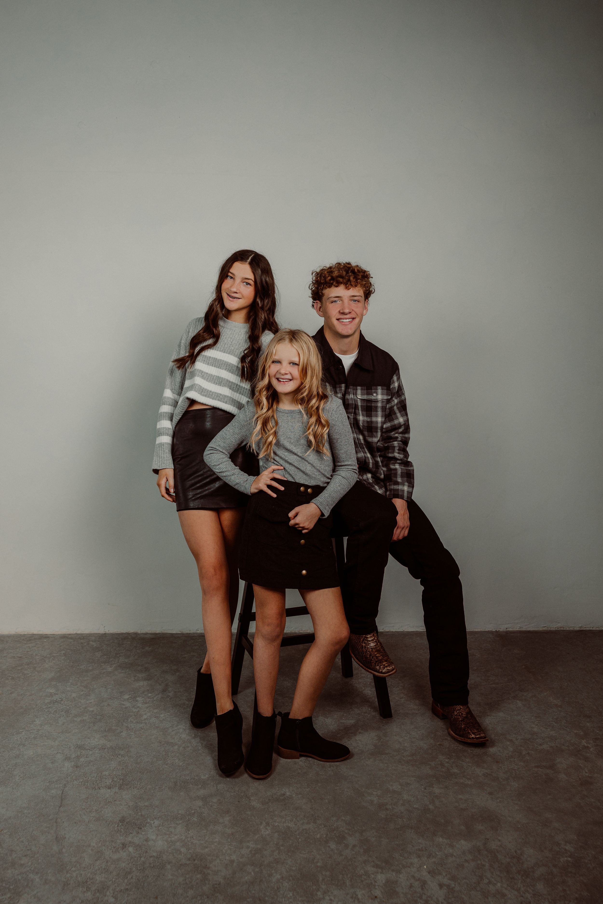 Kansas studio portrait session with casual outfits against grey background.