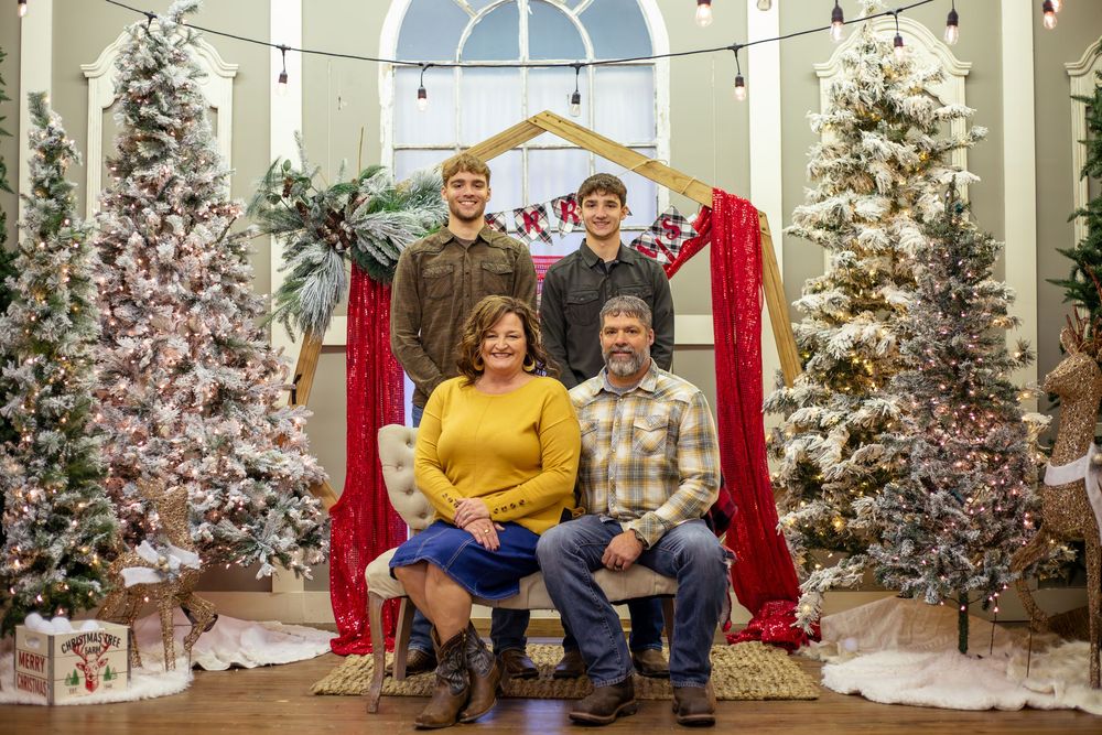 Standard family portrait indoors during holidays with festive colors in the background.