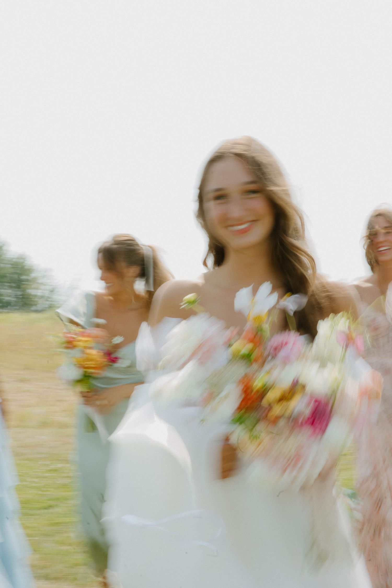 Dreamy motion-blur wedding photo with soft natural lighting and floral bouquets.