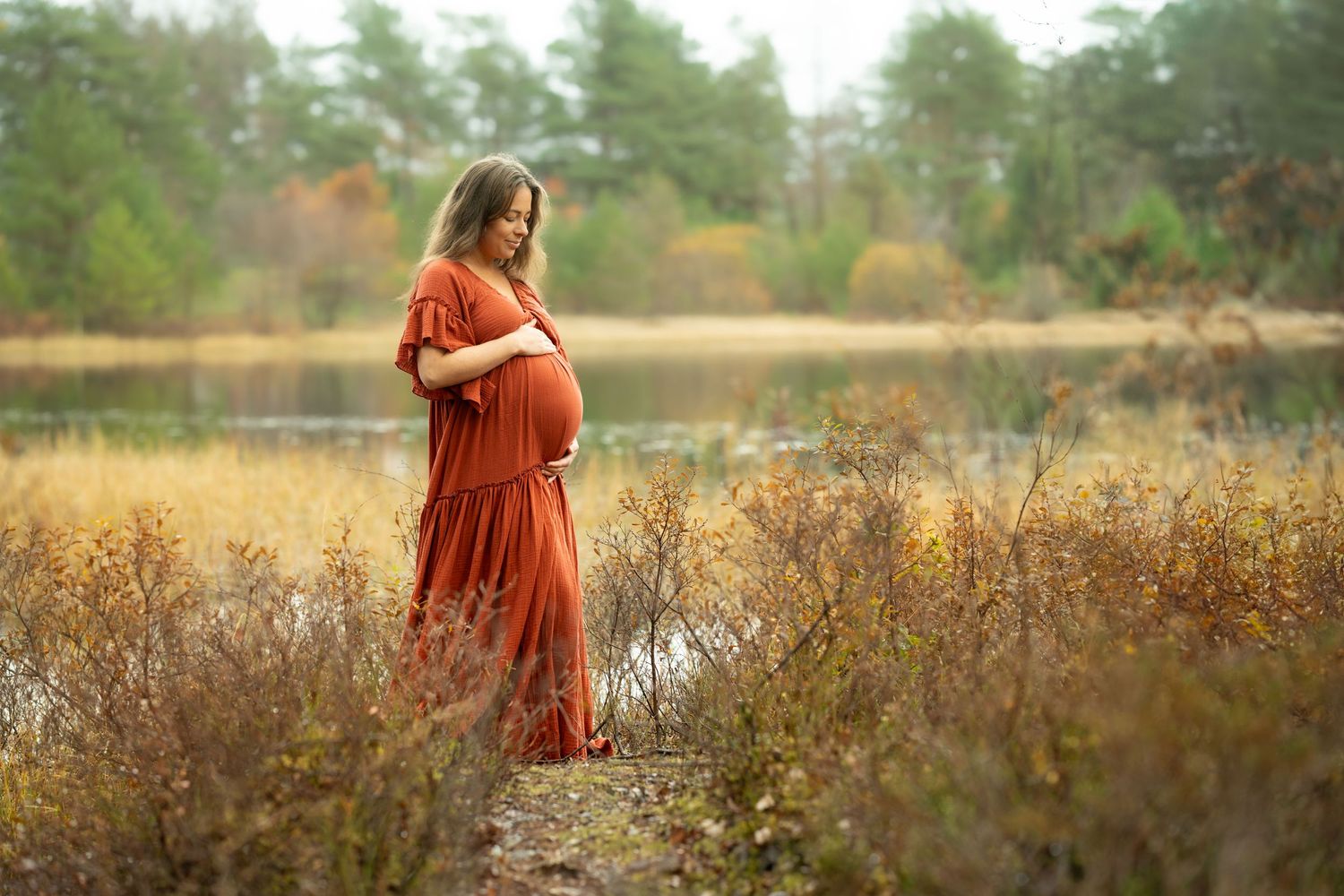 Gravidfotograf Sandnes - gravidfotografering i Rogaland arboret av nydelig tvillingmamma i rustrød kjole