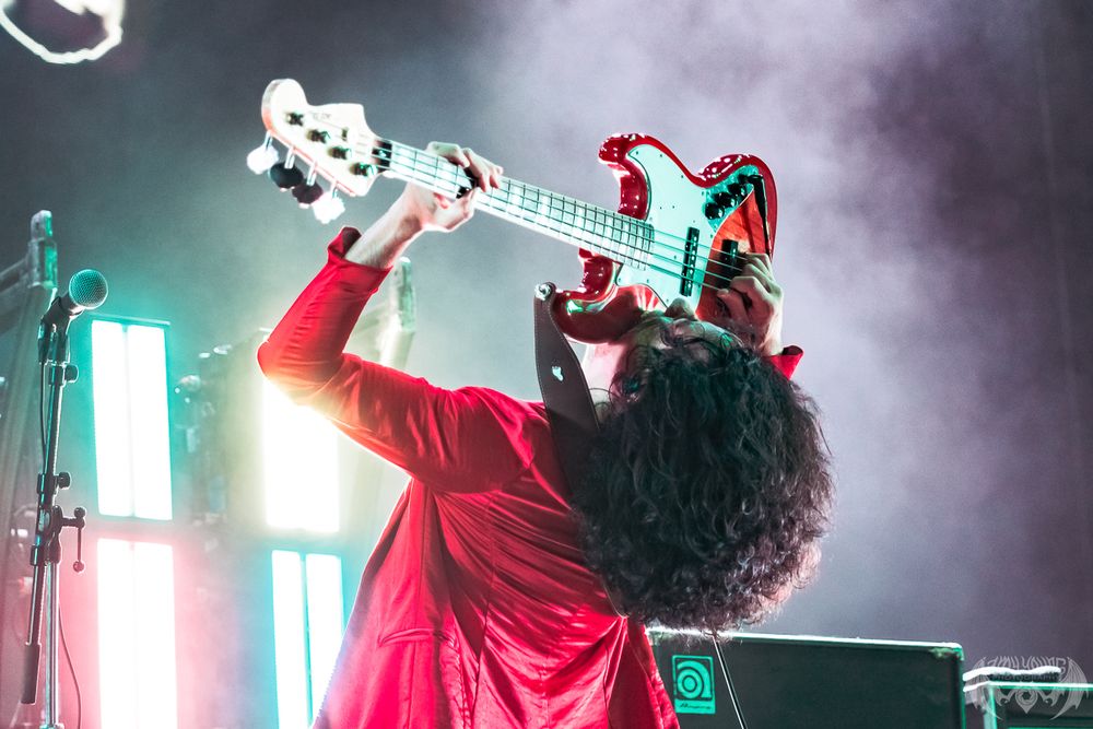 Performers on stage with dramatic fog and vibrant lighting effects during live show.