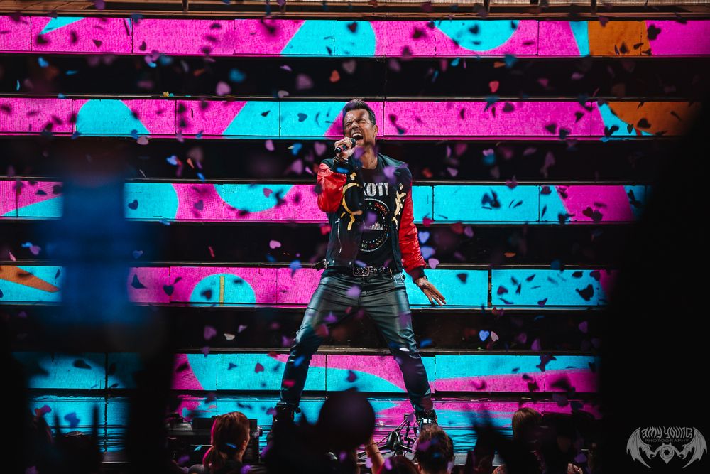Concert stage with vibrant pink and blue lighting design creating geometric patterns.