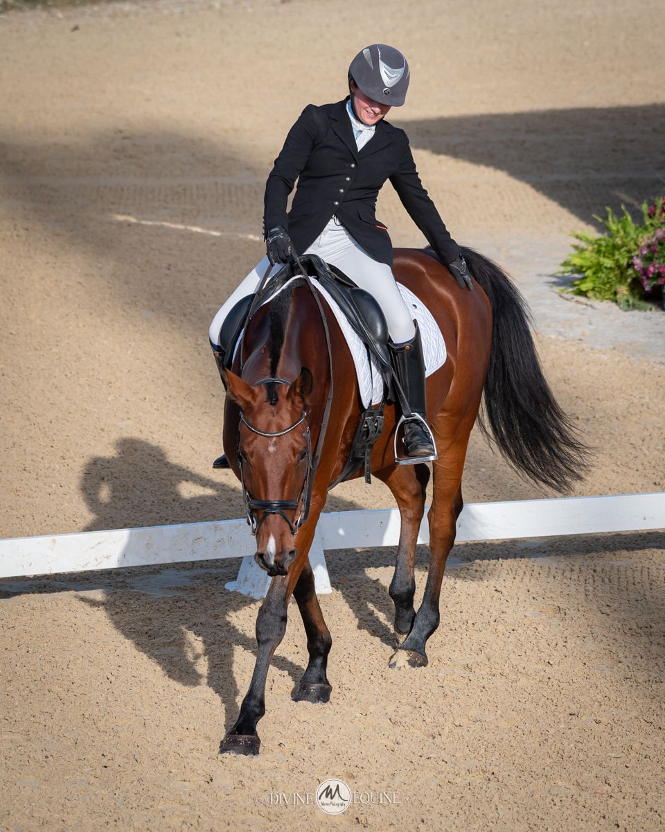 A smiling rider pats her horse after a dressage test in Langley, BC.