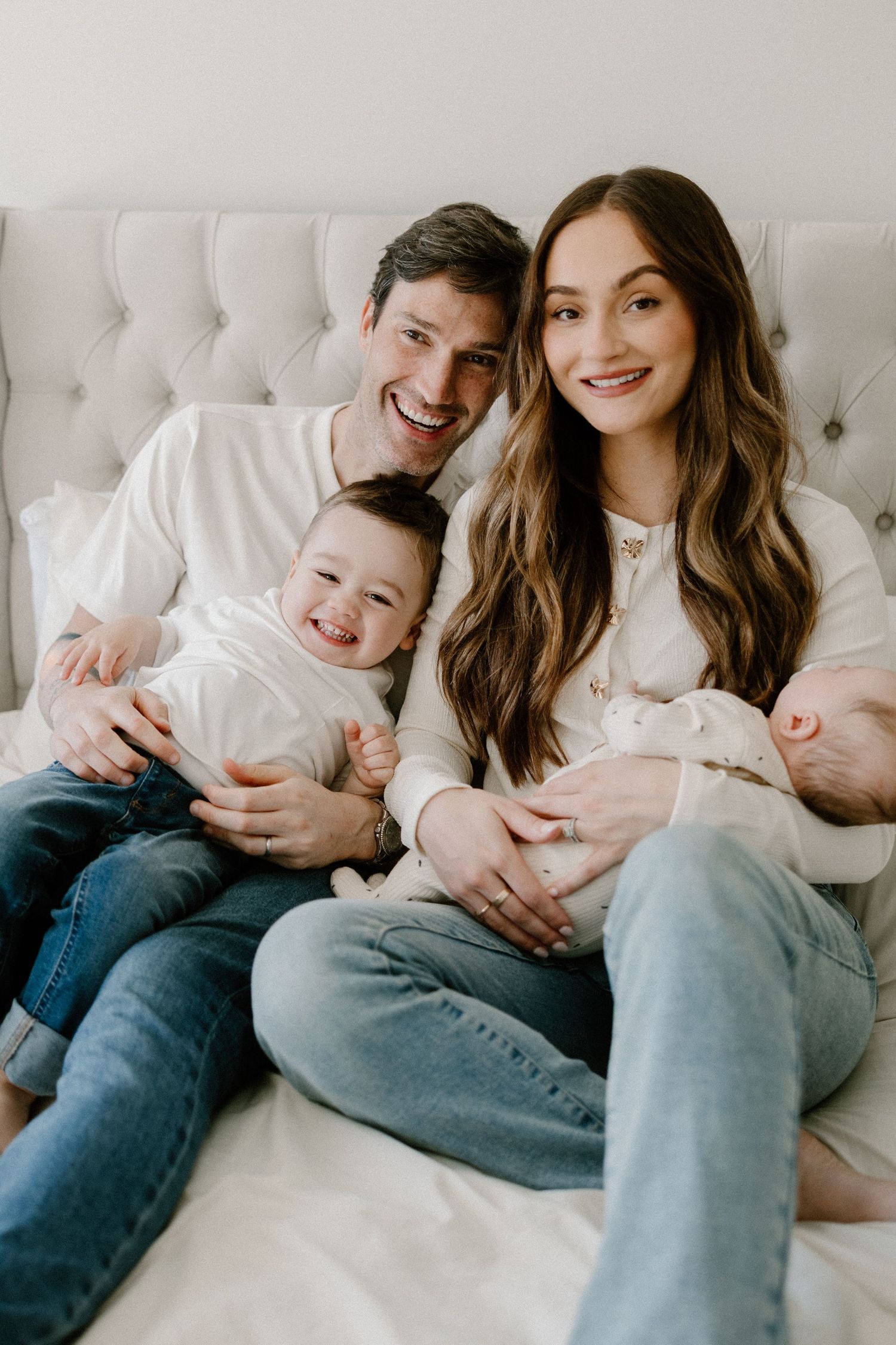 Family sits together on grass in a natural outdoor setting during a lifestyle photo session.