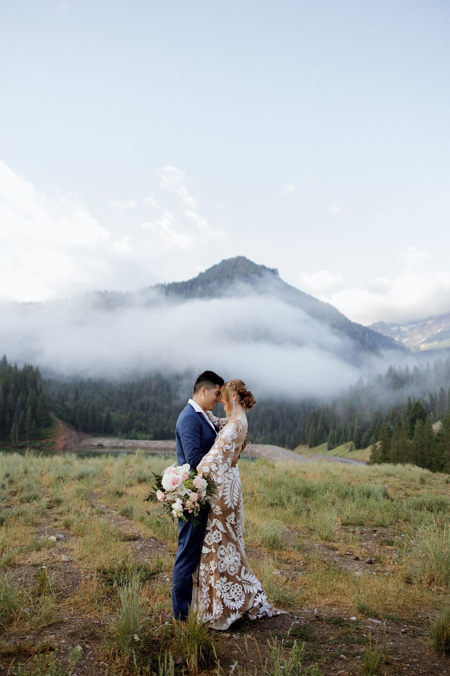 A romantic mountain elopement with misty peaks and evergreen forests as the backdrop.
