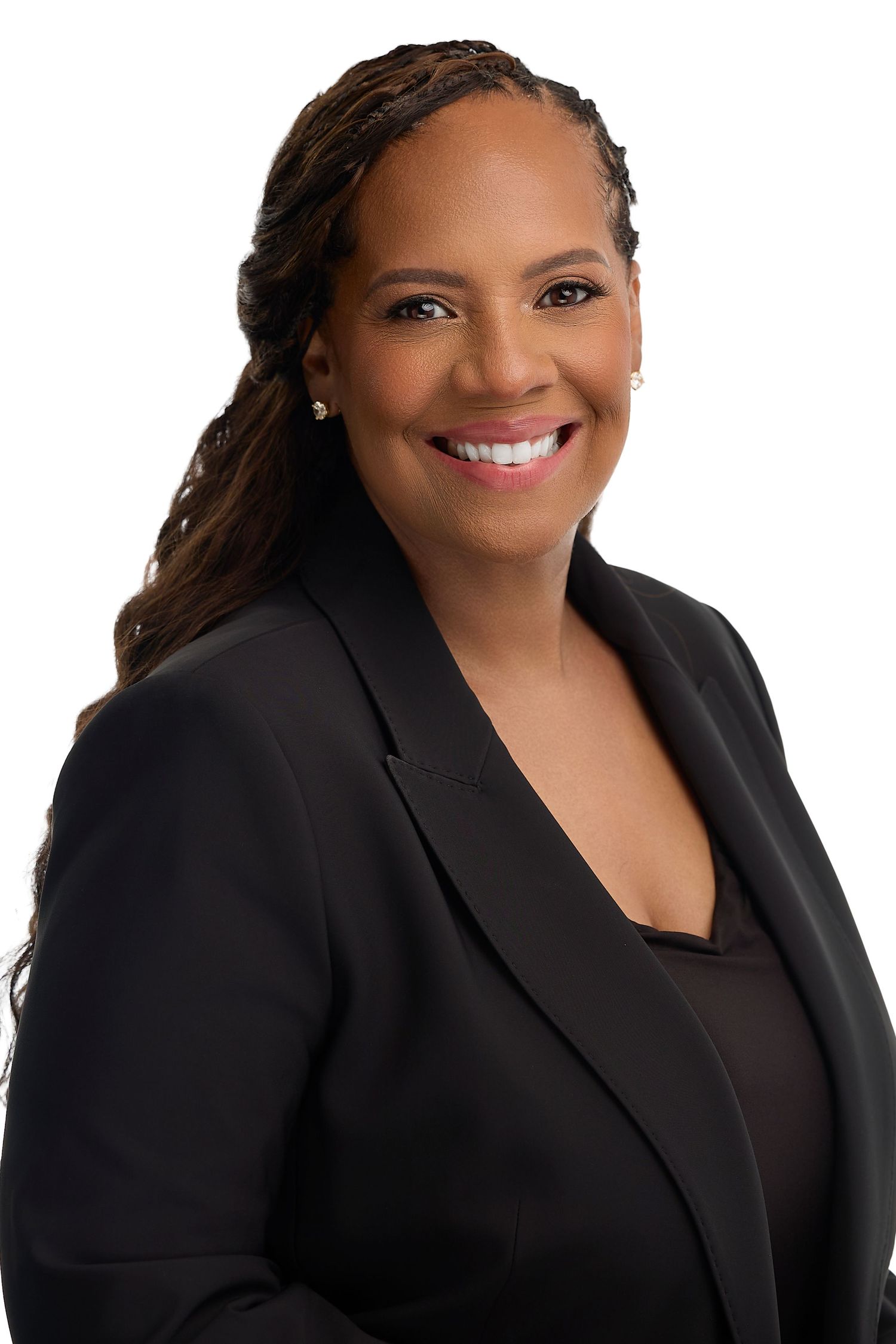 Professional headshot of a smiling woman in a black blazer with braided hair against a white background.