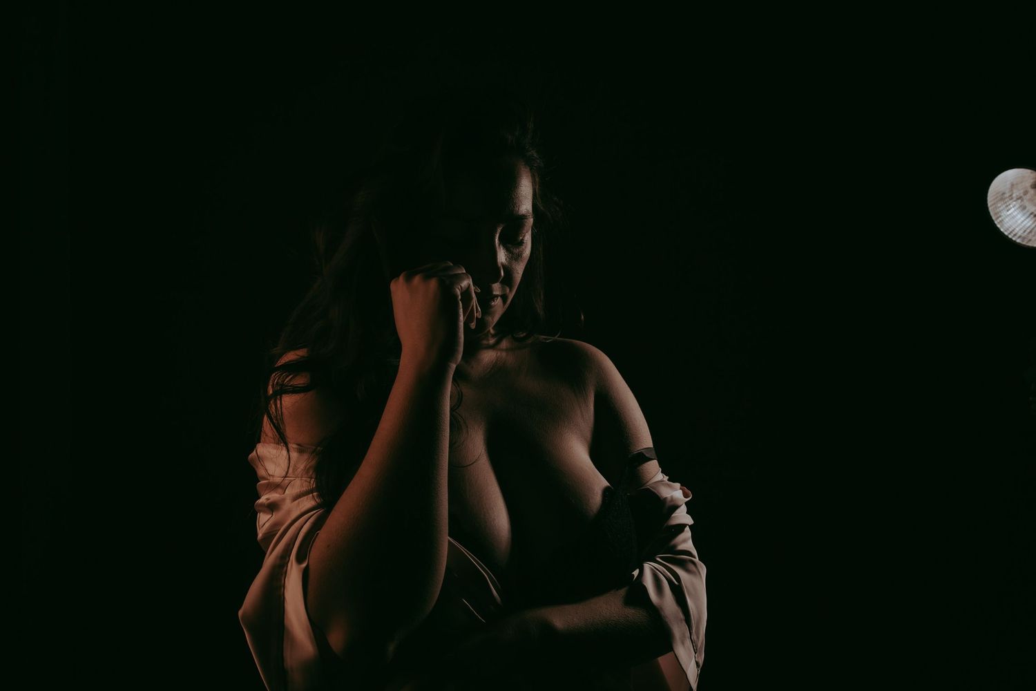 Vrouw met een zwarte lange jurk poseert voor een witte achtergrond in een studio in Helmond