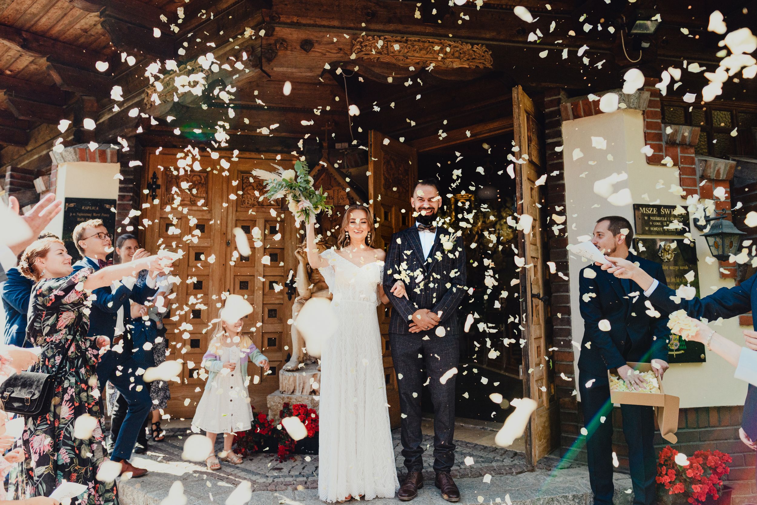 Wedding celebration moment with confetti being thrown at a rustic indoor venue.