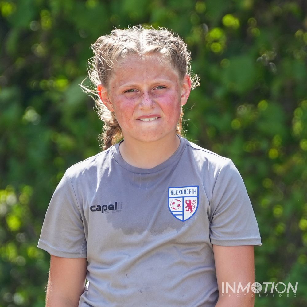 Soccer player wearing gray Alexandria team training jersey outdoors.