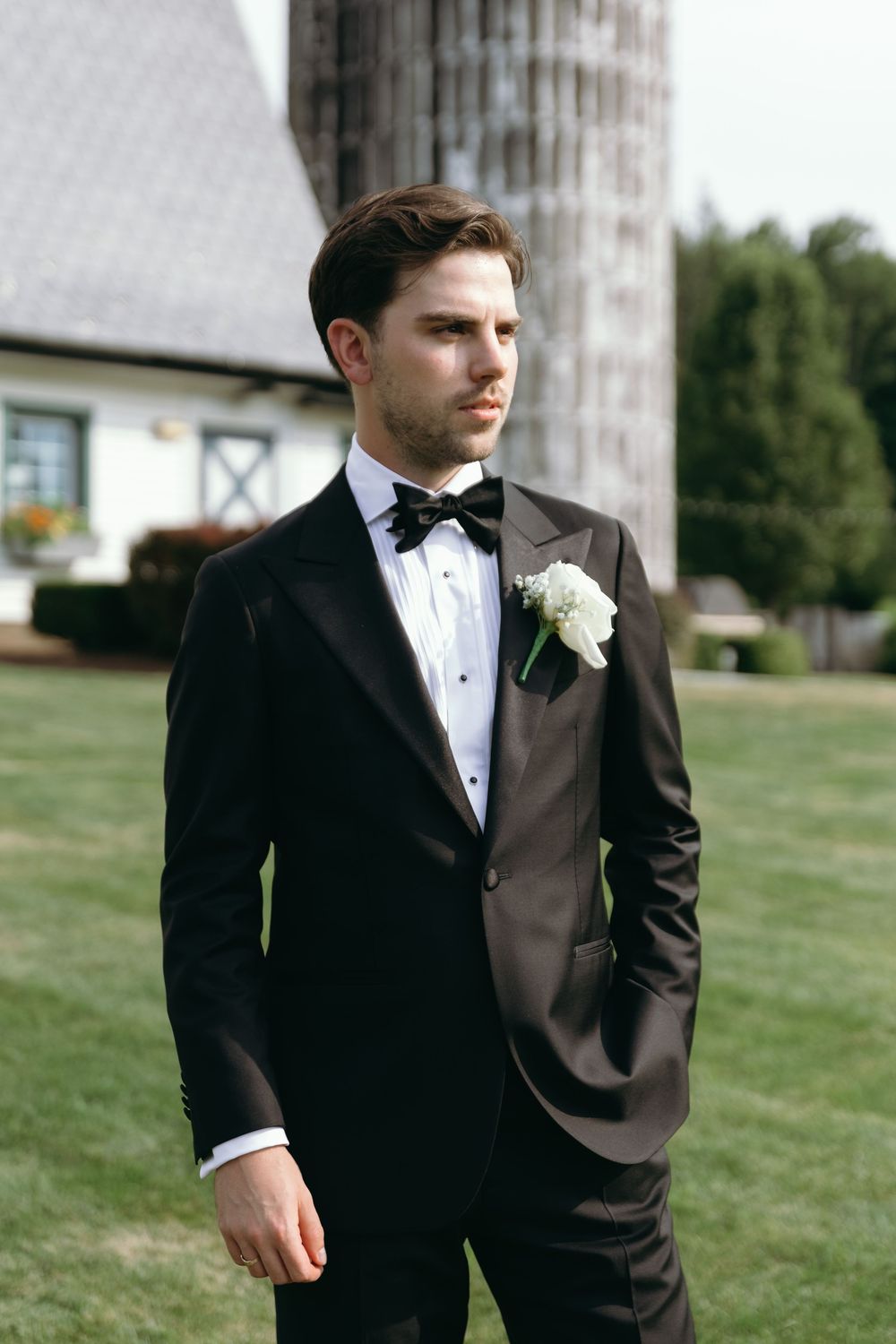Classic black tuxedo details photographed on a grassy lawn setting.