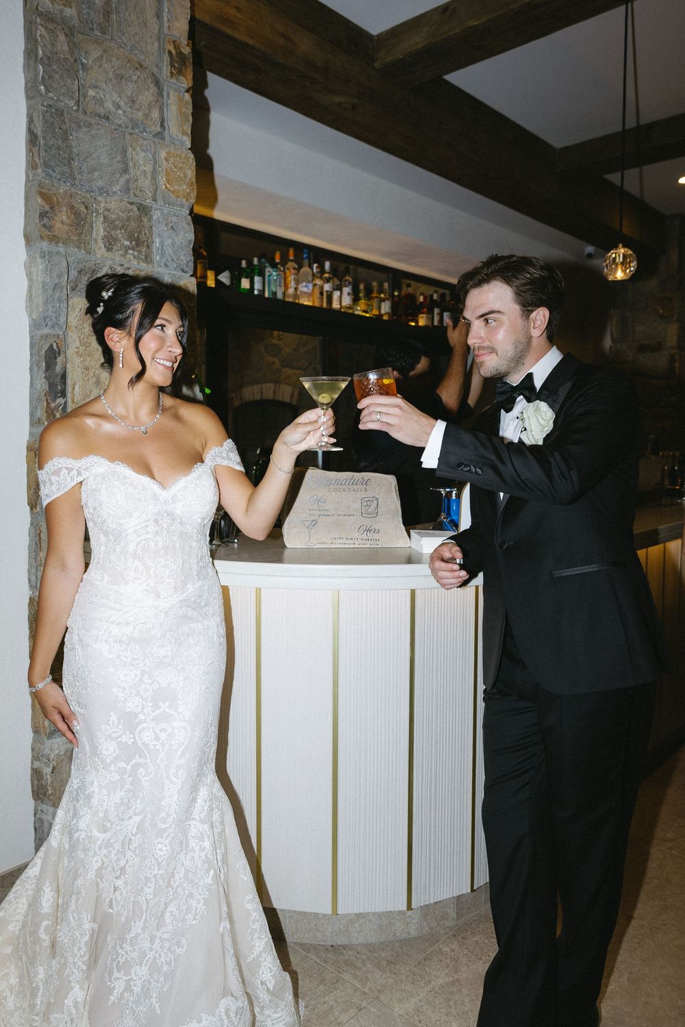 Couple dancing together at a wedding reception with a white lace dress and black suit.