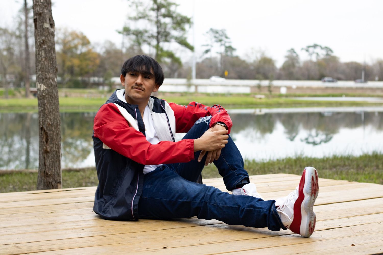 Casual outdoor portrait session on wooden deck near water.