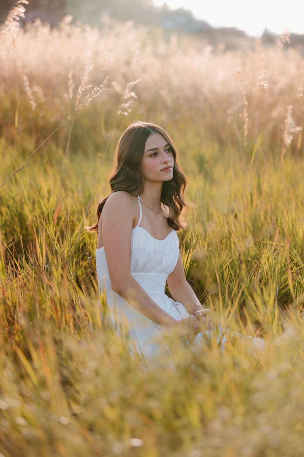 Portrait in mint green off-shoulder top with soft natural lighting and bokeh background.