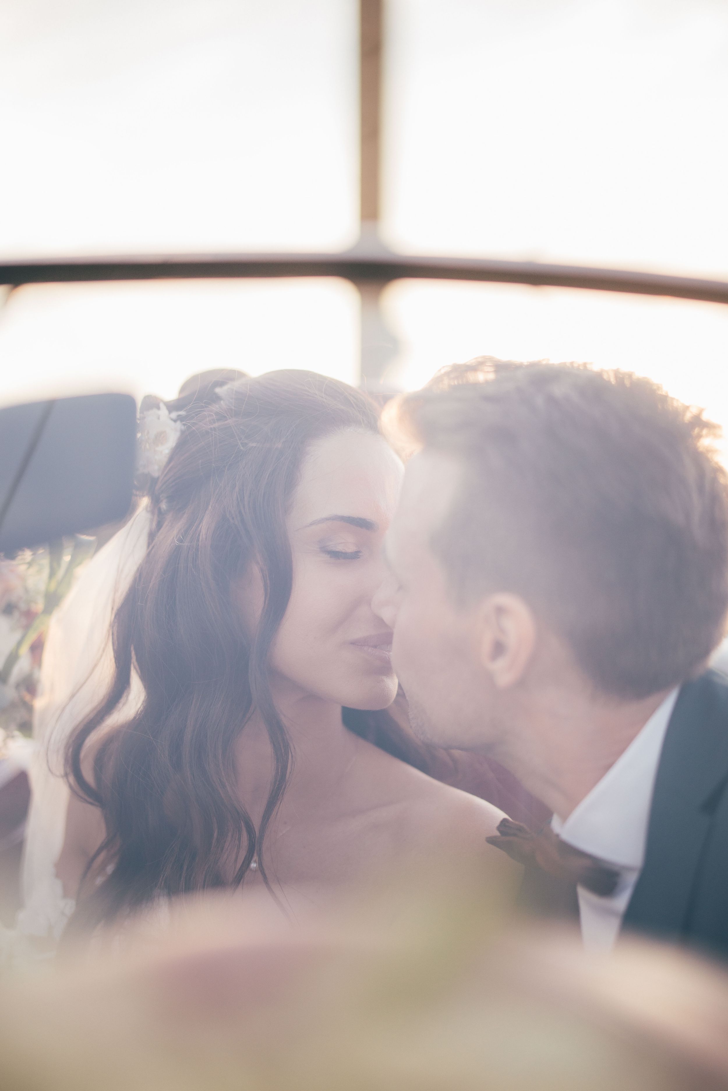 A romantic couple sharing an intimate kiss in soft dreamy lighting.
