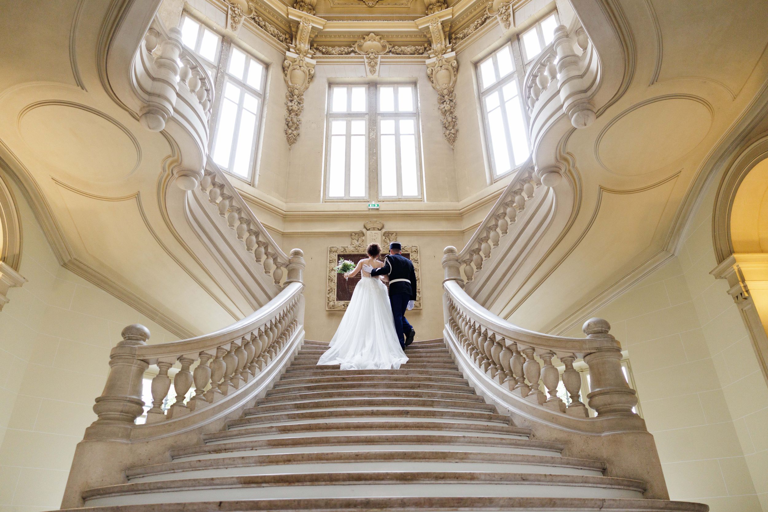 Grand baroque marble staircase with ornate balustrades in a luxurious palace setting.