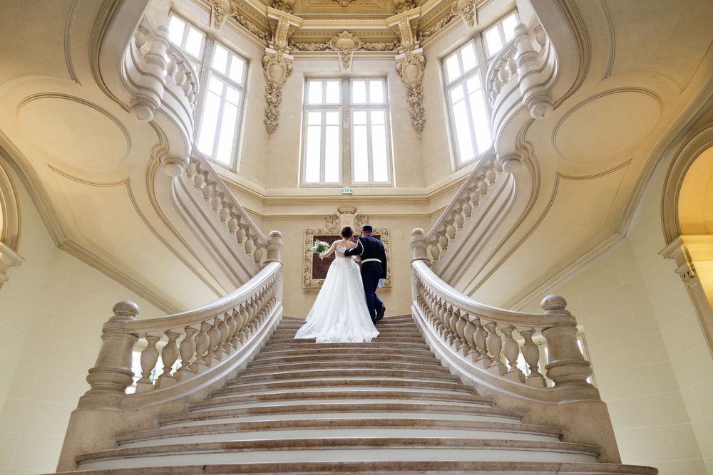 Grand baroque marble staircase with ornate balustrades in a luxurious palace setting.