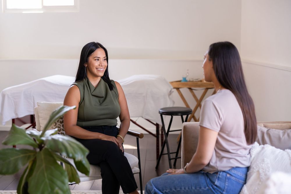 woman acupuncturist branding photo in Issaquah, WA with client acupressure treatment doing client intake and chatting with client