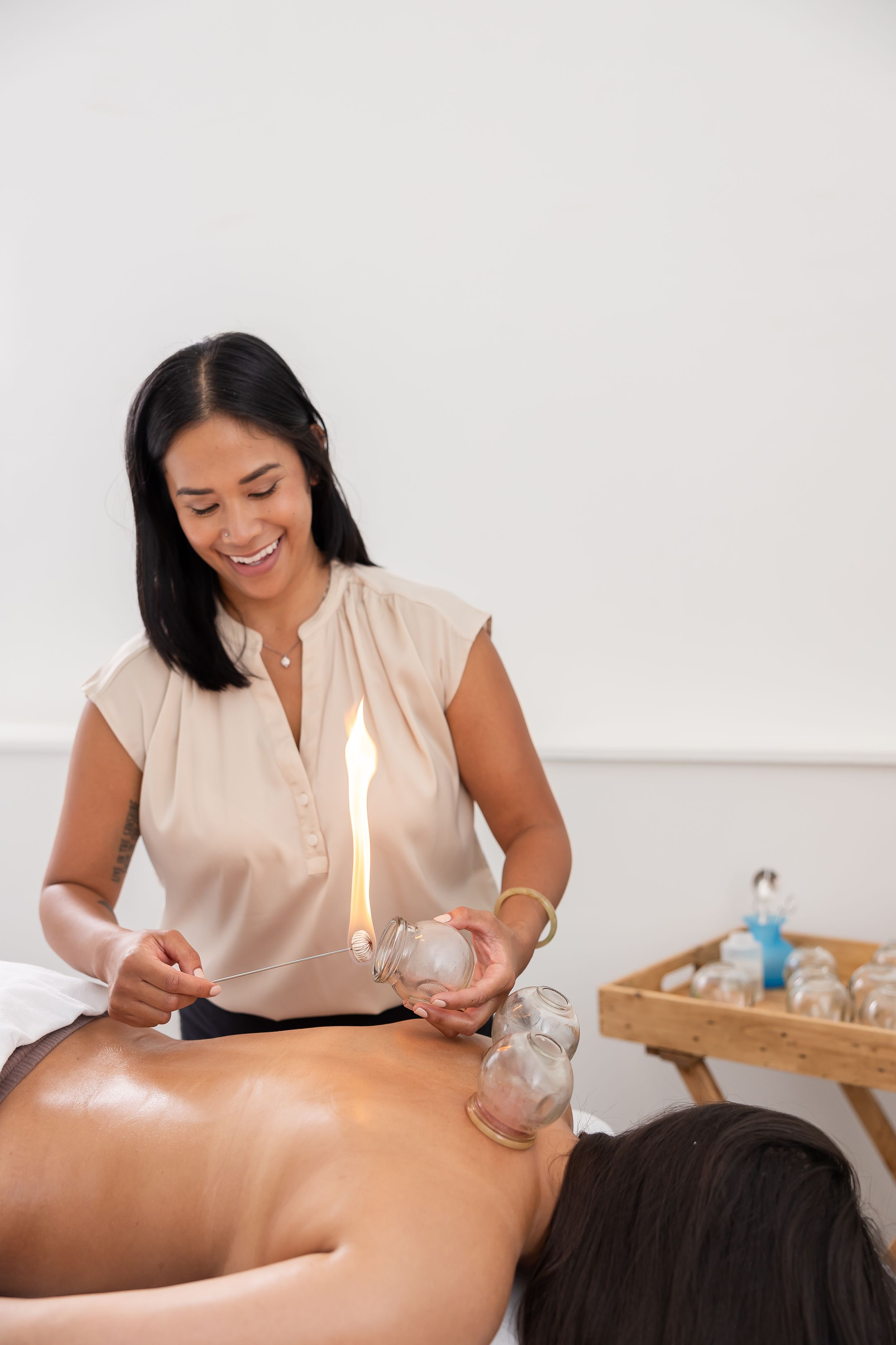 woman acupuncturist branding photo in Issaquah, WA with client acupressure treatment using fire cupping on woman's back during sesion