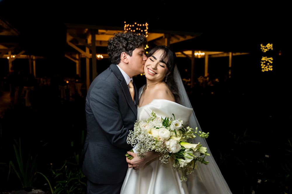 A romantic wedding couple shares an intimate moment during their evening reception celebration.