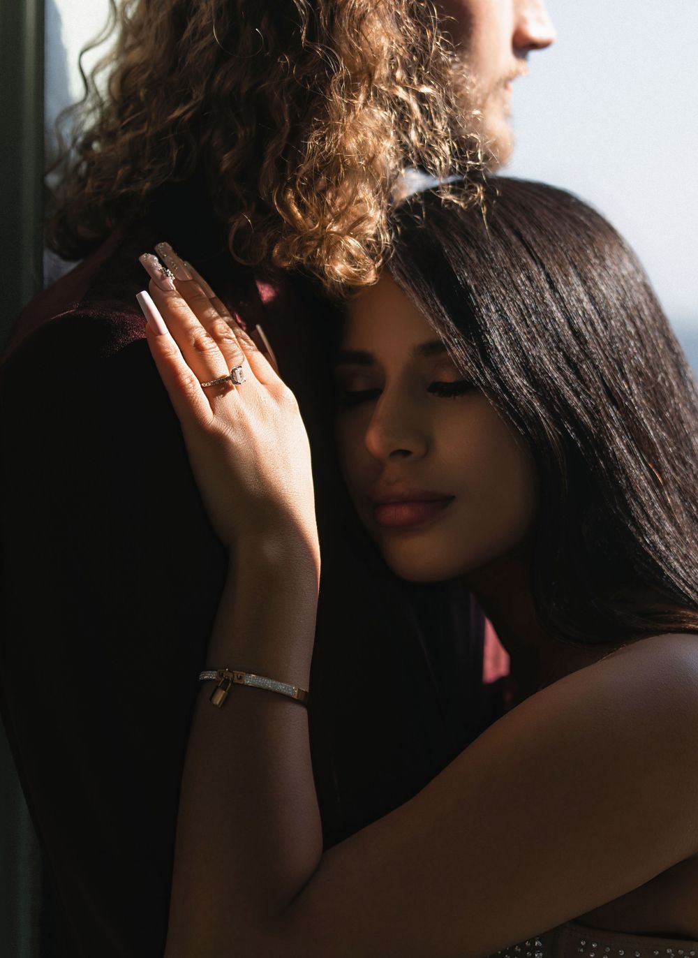 Artistic portrait series showing a figure in dramatic shadows with jewelry and dark hair.