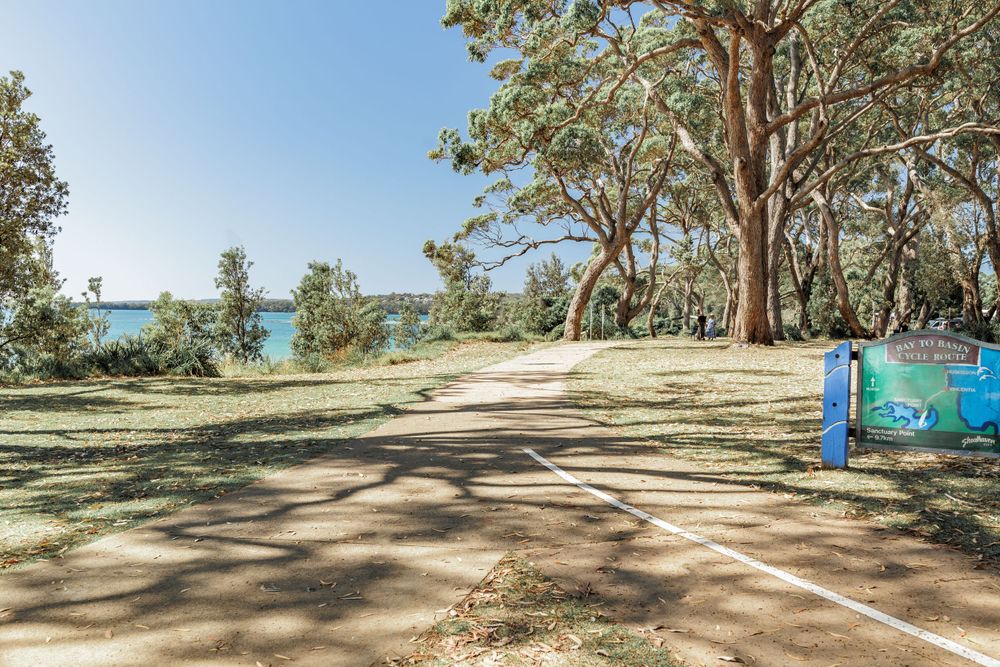 A coastal walking path under eucalyptus trees with ocean views and colorful mural art at Huskisson Jervis Bay NSW